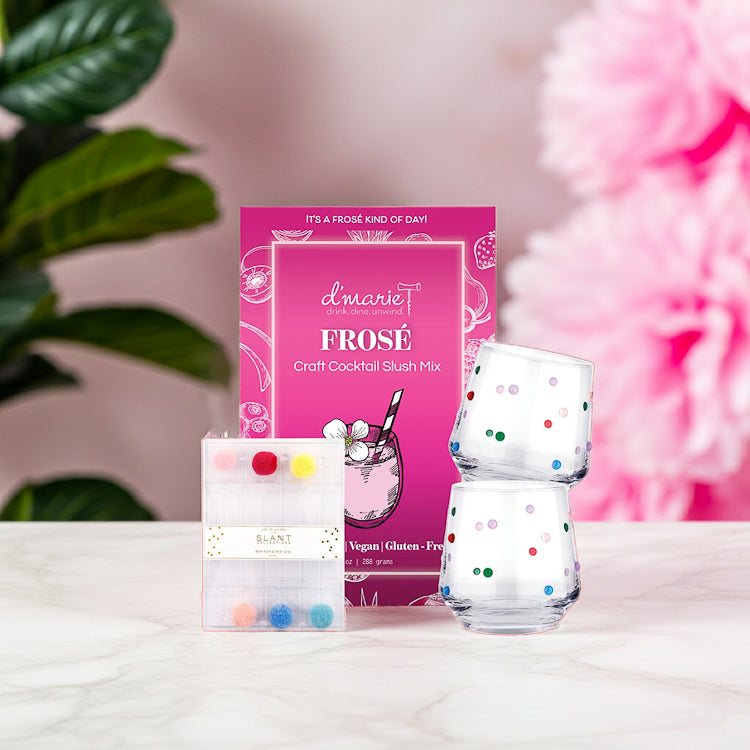 Frosé craft cocktail slush mix with colorful polka dot design wine glass and drink stirrers on a light surface.