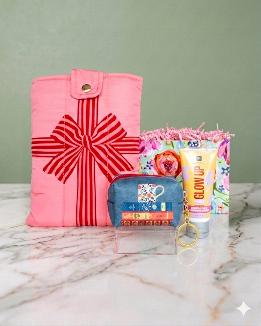 book reader accessories gift set includes pink book/e-reader cover with red bow, small blue with a stack of book designed keychain pouch, and infused sea-salt hand cream. 